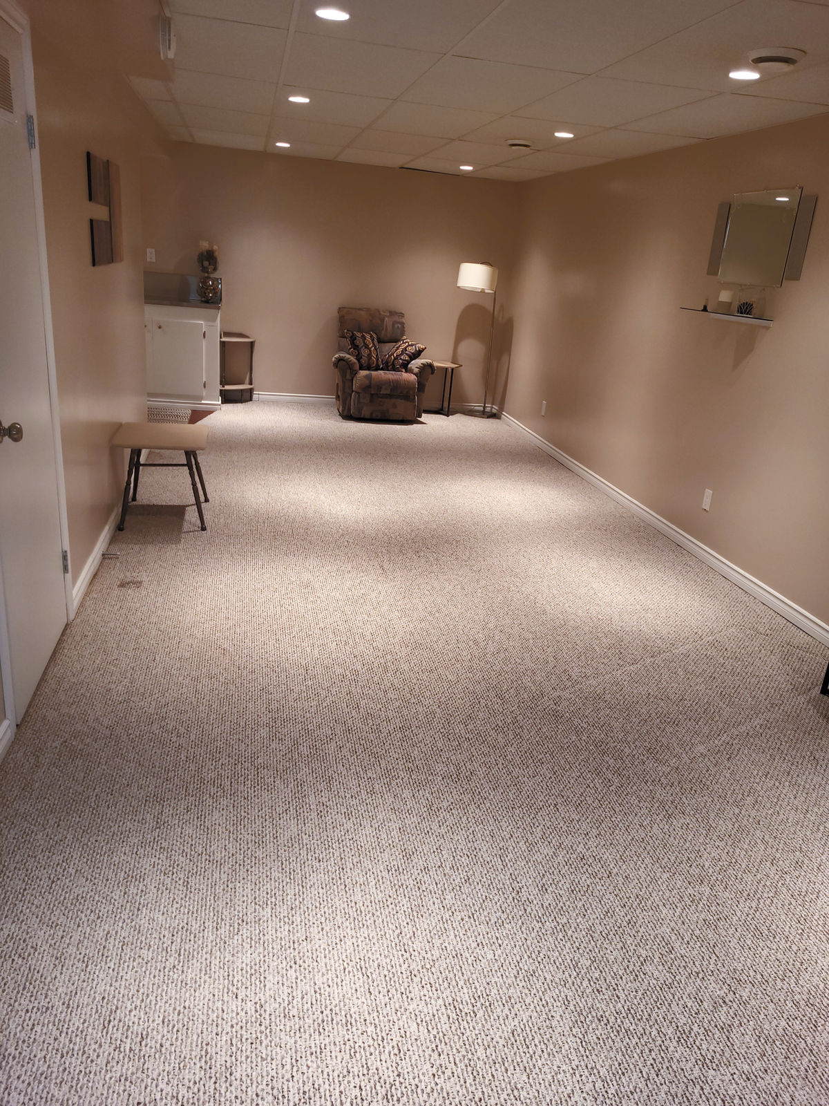 A basement family room with freshly cleaned wall-to-wall carpet